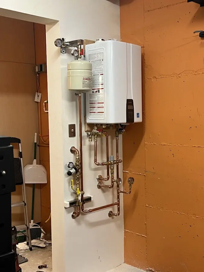 Plumbing technician inspecting water heater connections in Morganton